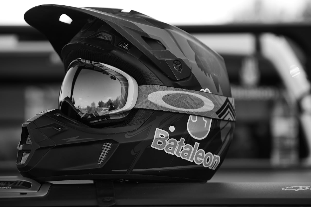 Black motorcycle helmet with goggles on a surface, featuring Bataleon logo in black and white.